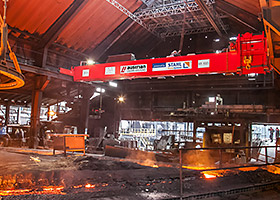 Ponte rolante de processo com técnica de elevação e de pontes rolantes da STAHL CraneSystems para o carregamento de altos-fornos na indústria do aço.